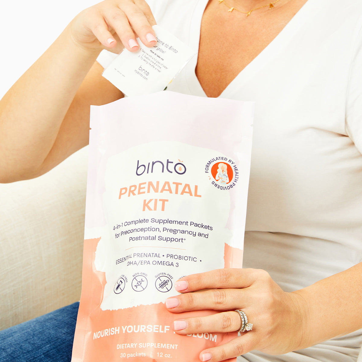 Woman holding Binto Prenatal Kit and supplement pack
